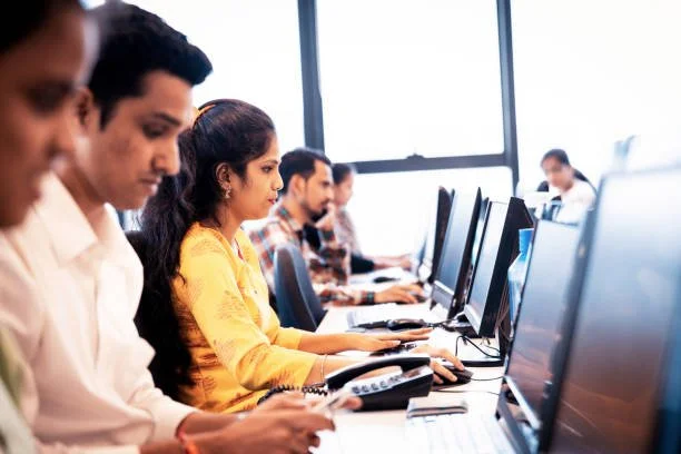 Outsourcing, Mumbai, Service - Group of call center executives seated in a row working on their desktop PC